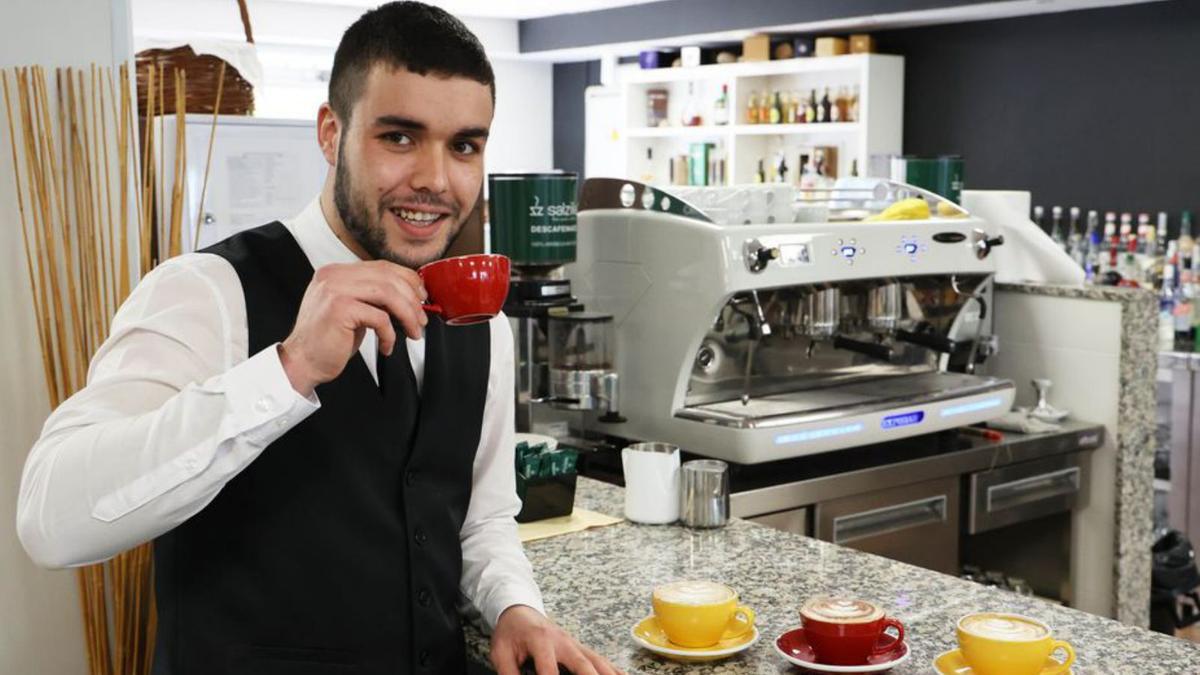 Un barista junto a varias tazas de café.