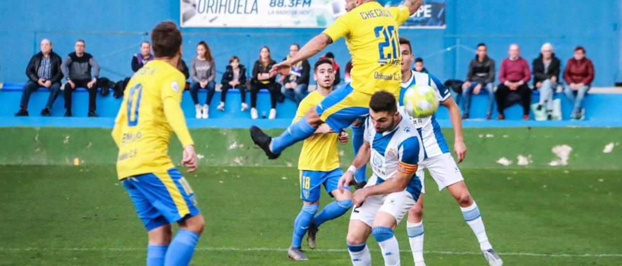 Chechu Flores, en el aire, disputa un balón aéreo con la defensa del Espanyol B.