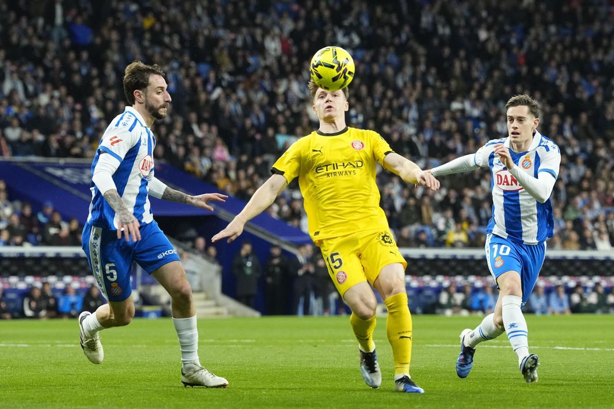 CORNELLÁ-EL PRAT (BARCELONA), 16/01/2026.- Los jugadores del Espanyol Fernando Calero (i) y Pol Lozano (d) disputan el balón con Viktor Tsygankov (c), del Girona, durante el partido de LaLiga entre el Espanyol y el Girona, este viernes en el RCDE Stadium. EFE/Enric Fontcuberta