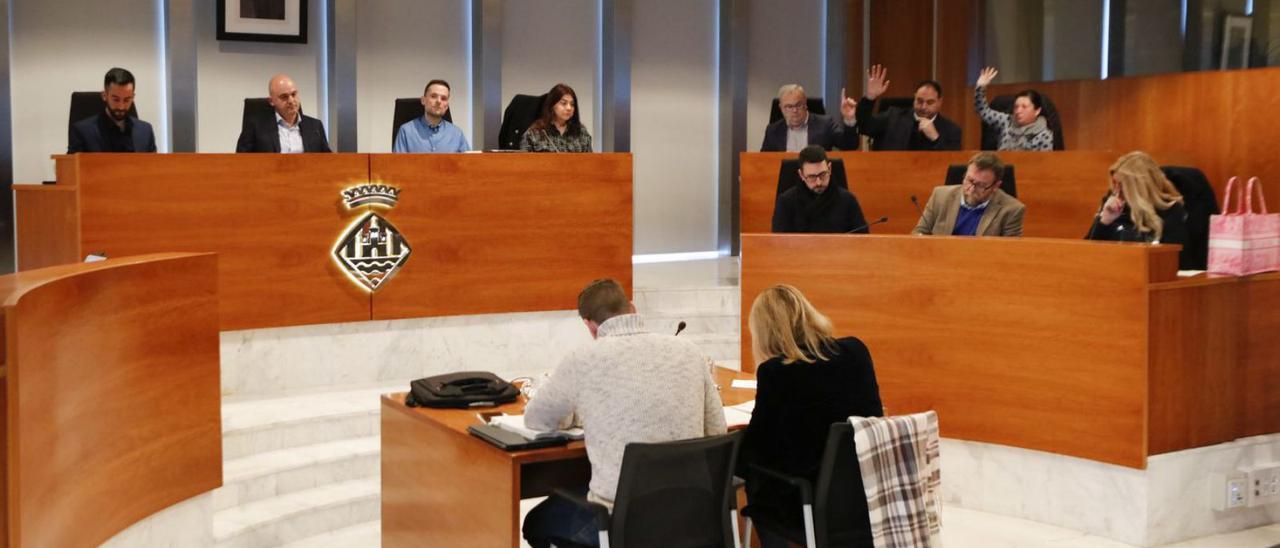 Los tres consellers del PSOE, ayer, levantan el brazo durante una votación en el pleno. | J. A. RIERA