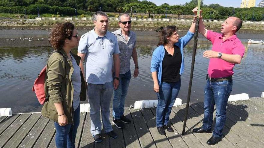 Ana Miranda y Manuel Baldomir muestran la altura de los lodos, en la ría de O Burgo.