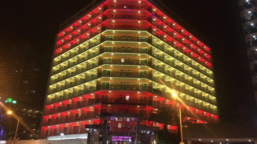 Imagen anoche del hotel Calypso, de la cadena Servigroup, uno de los que tres establecimiento iluminado con los colores de la bandera de España en Benidorm.