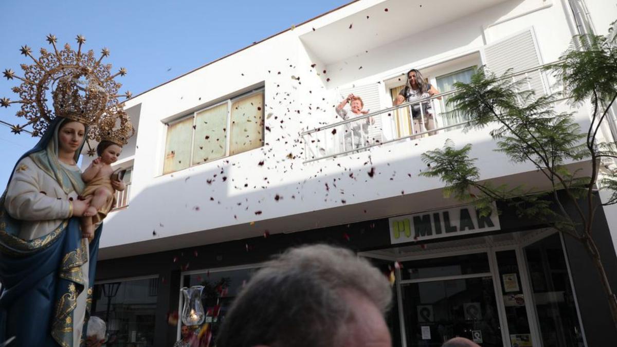 Los vecinos tiran pétalos de rosa al paso de la procesión.