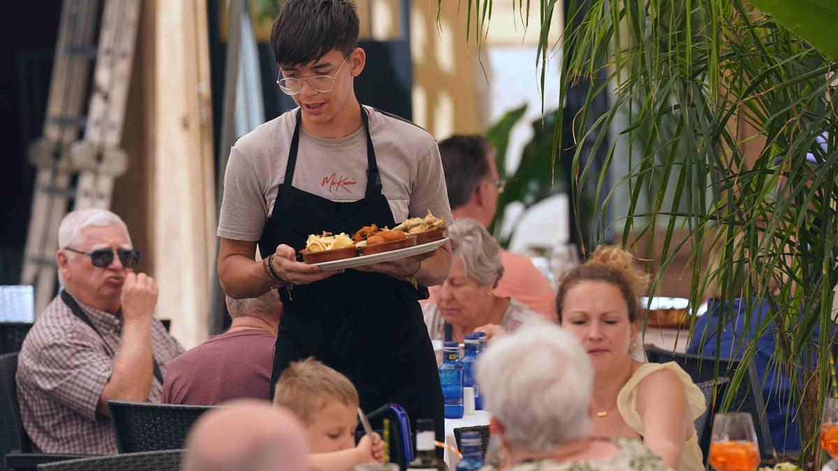 Un camarero atienda a los clientes en las terrazas de los restaurantes en el Centro de Málaga.