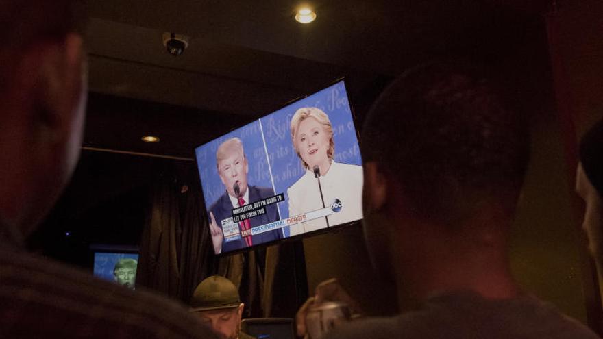 Varias personas ven el debate por televisión.