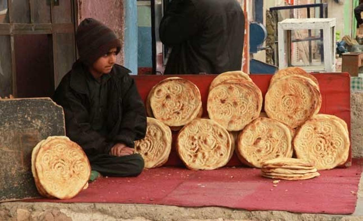 Un noi ven pa en un carrer d’Herat (Afganistan). Diverses informacions apunten que l’economia afganesa continua depenent en gran mesura de l’ajuda estrangera, l’agricultura i l’intercanvi comercial amb països veïns.