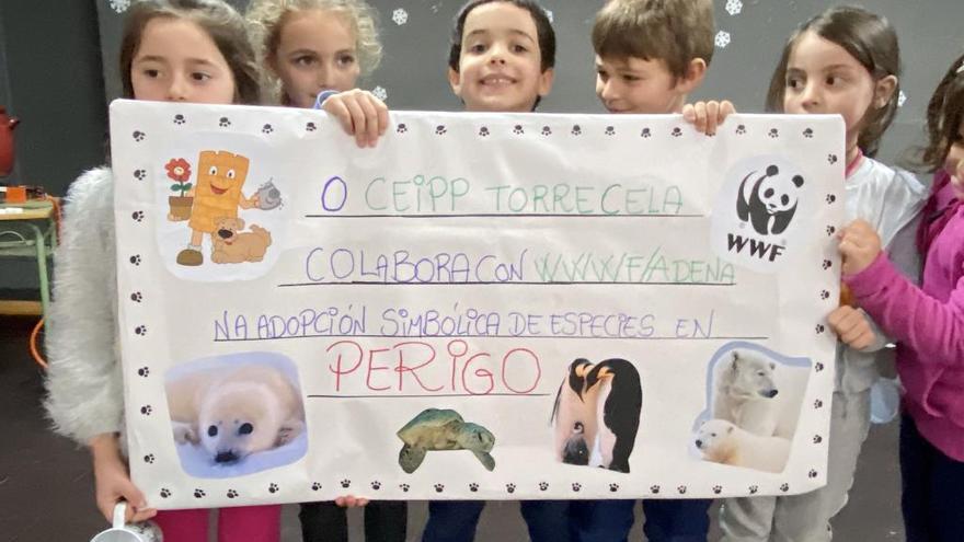 Niños de A Torre portando el cheque para apadrinar los animales.// Fdv