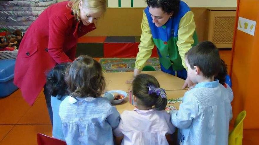 La edil reponsable de la guardería municipal con varios niños.