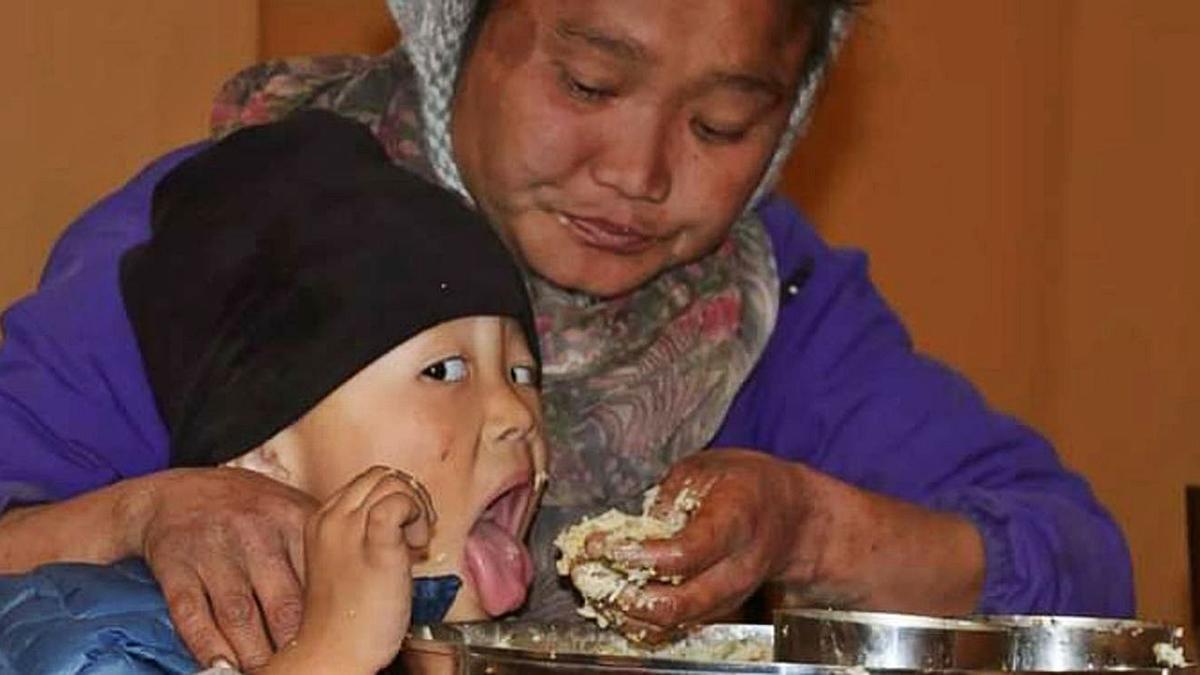 Un niño come con su madre en el comedor de Hugging Nepal en Katmandú. | 
