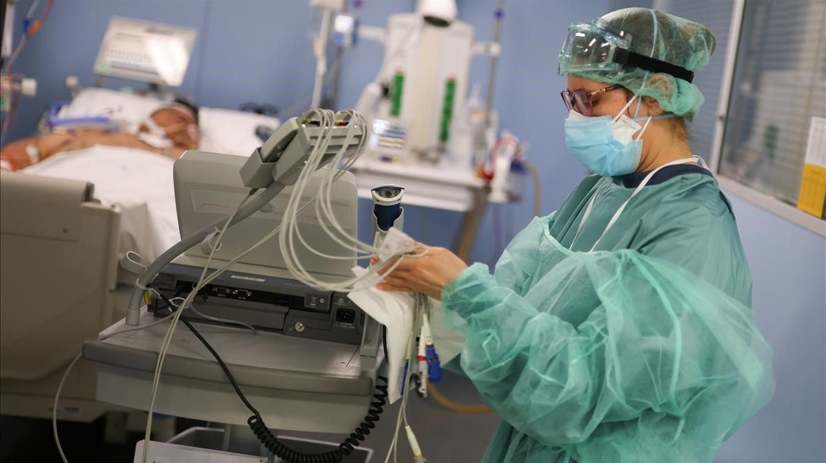 Un miembro del personal del hospital se prepara para tratar a un paciente de covid, en la Unidad de Cuidados Intensivos del Hospital de Sant Pau.