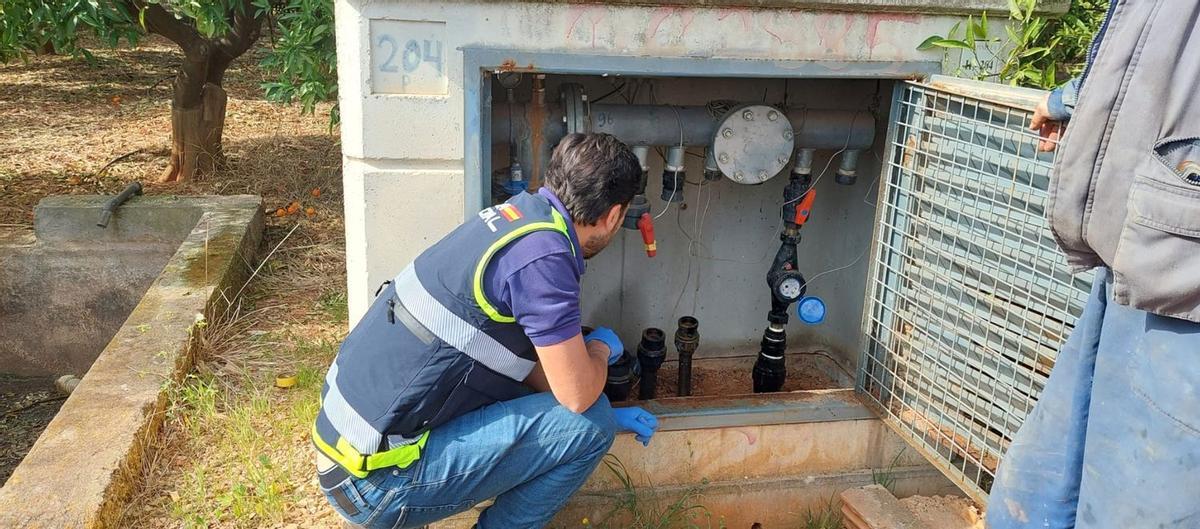 Un agente de la Policía Nacional inspecciona uno de los hidrantes dañados por los ladrones.