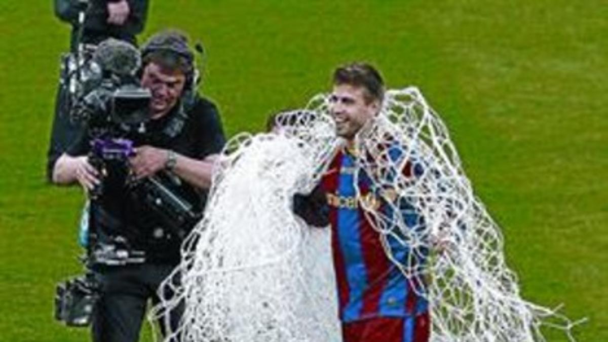 Piqué se dirige al vestuario con  las redes de una de las porterías de Wembley como trofeo.