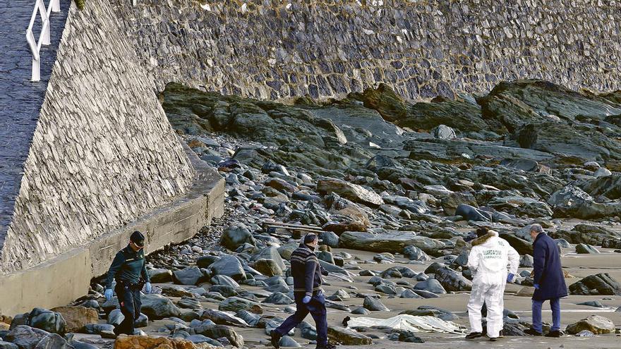 Agentes junto al cadáver hallado en la playa de Aguilar, en Muros de Nalón.