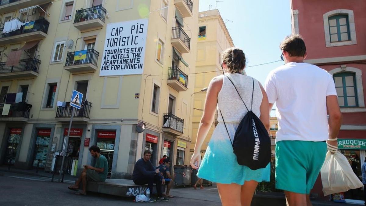 Una pareja pasea por el barrio de la Barceloneta, donde proliferan los pisos turísticos