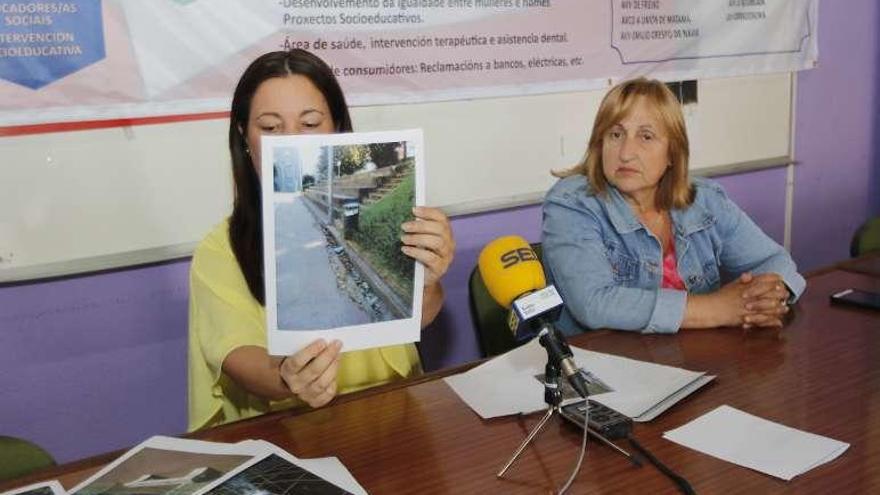 La presidenta de la Favec muestra una imagen de una papelera rota y desperfectos en el pavimento en Freixeiro. // Alba Villar