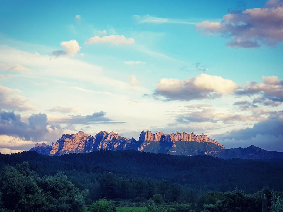 Montserrat. Entre alguns núvols, la muntanya de Montserrat apareix il·luminada per la resplendor del sol.