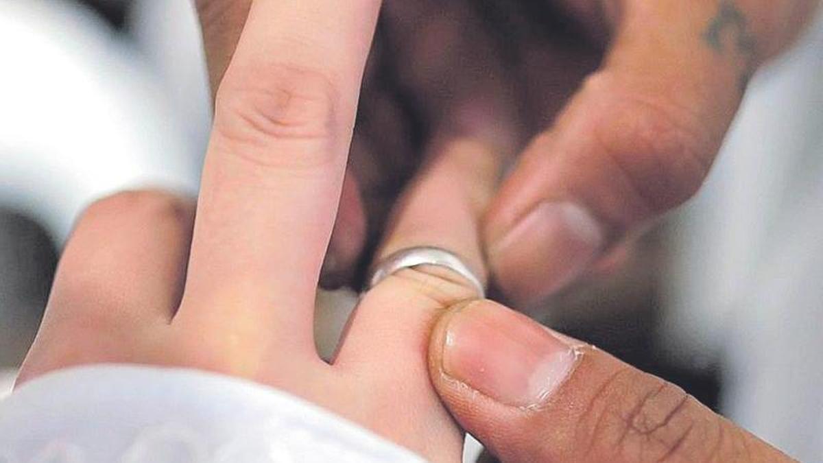 Una pareja intercambia los anillos matrimoniales.