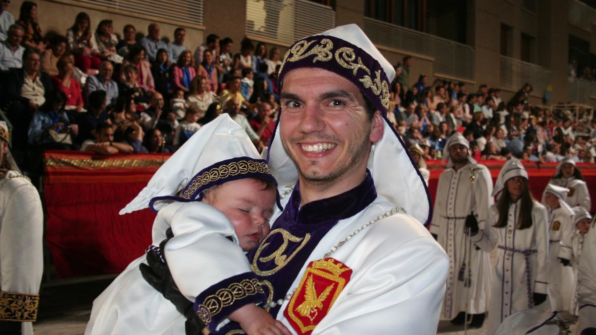Luis Montiel Camacho con su hijo Francisco Montiel Mateo, de diez meses, dormido en sus brazos por la carrera principal integrando la ‘cloca’ del Paso Blanco.