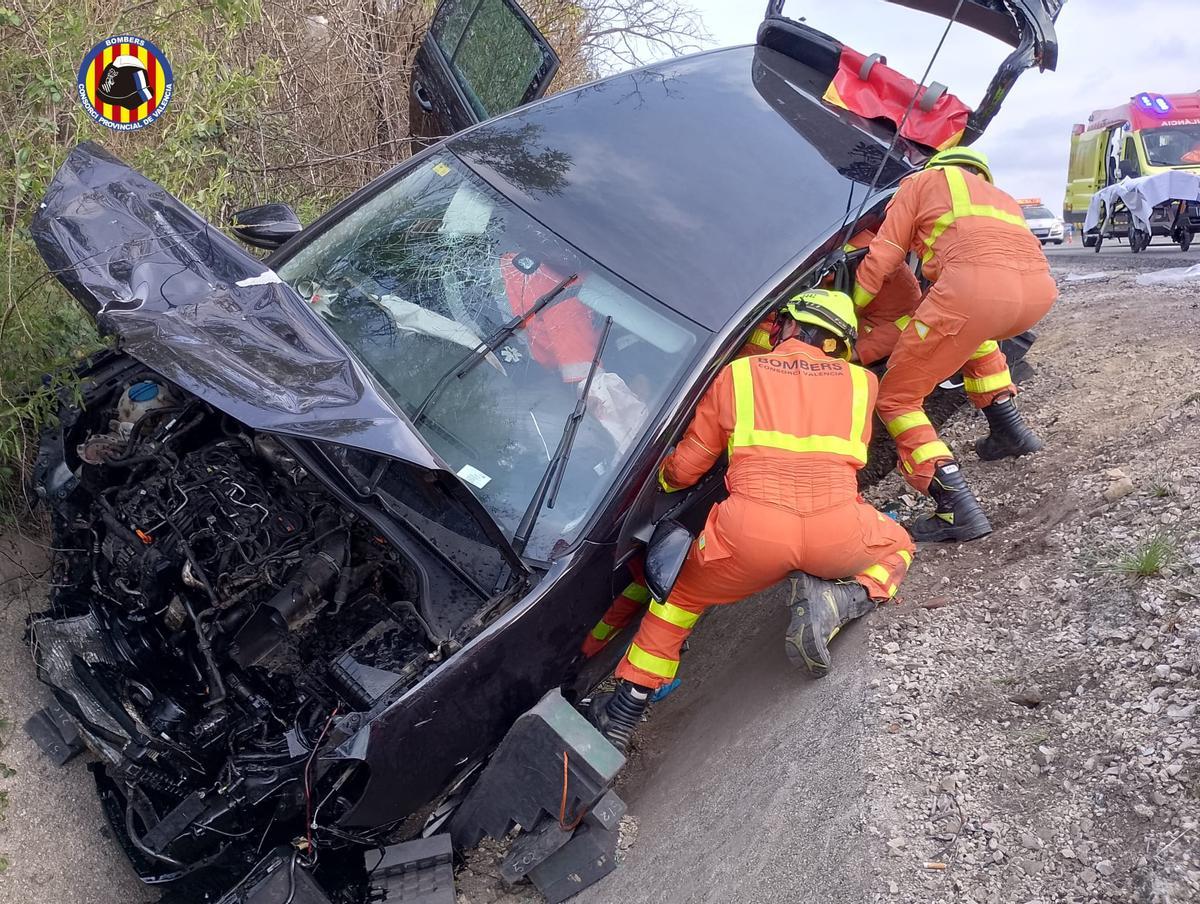 Momento en el que los bomberos excarcelan al ex arzobispo atrapado en el coche.