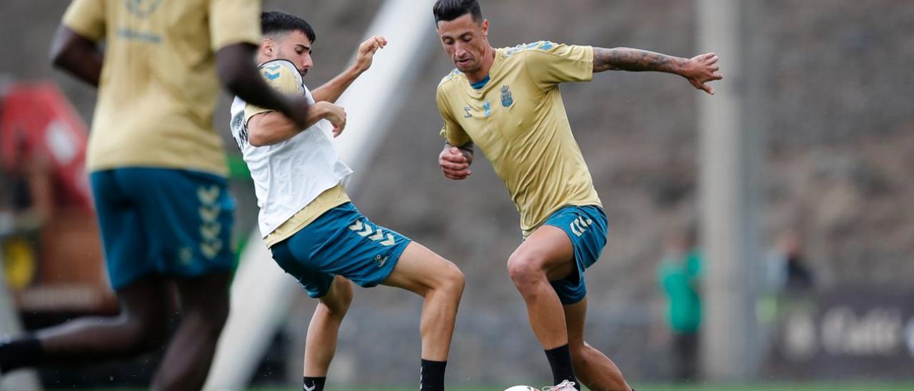 El tinerfeño Maikel Mesa controla el esférico ante la presión de Fabio González, ayer, durante la sesión de trabajo en la ciudad deportiva de Barranco Seco.