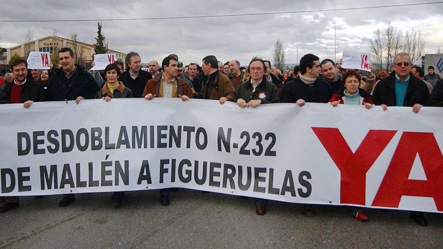 Pancarta exigiendo en la N-232 el desdoblamiento en una protesta de 2004 en la que los municipios llegaron a cortar la carretera para hacerse oír. | EL PERIÓDICO
