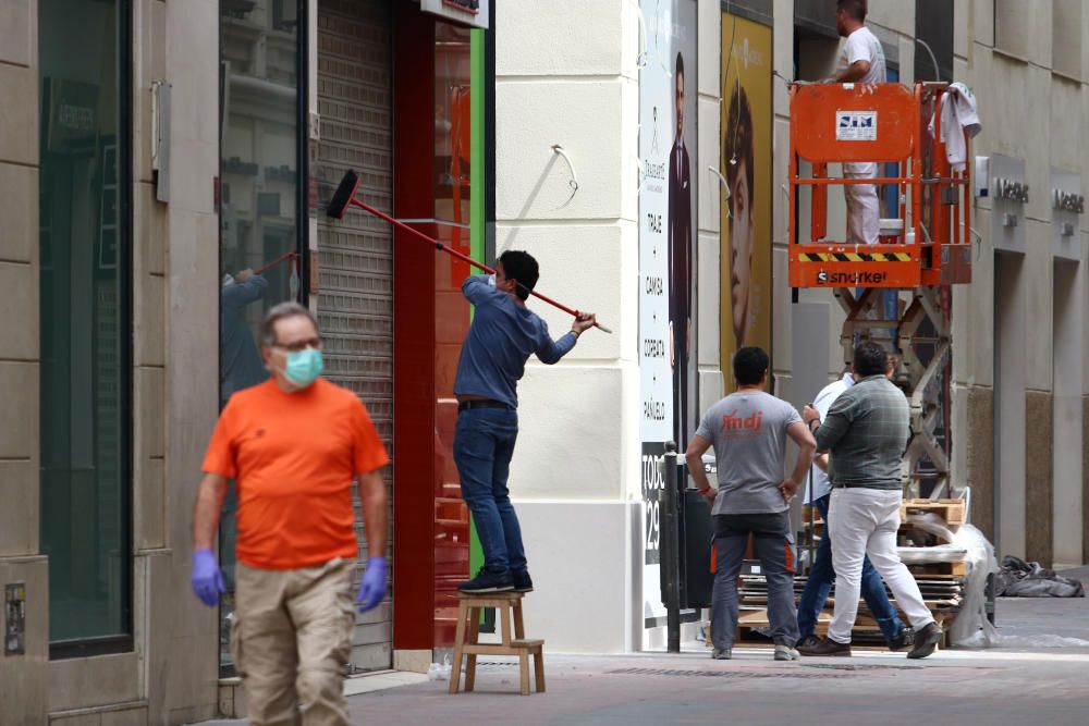 Mascarillas y guantes ya se han convertido en un complemento más de los malagueños, que siguen aprovechando las franjas horarias permitidas para dar sus paseos mientras los pequeños establecimientos se preparan para una reapertura cuando el progreso en la desescalada lo permita