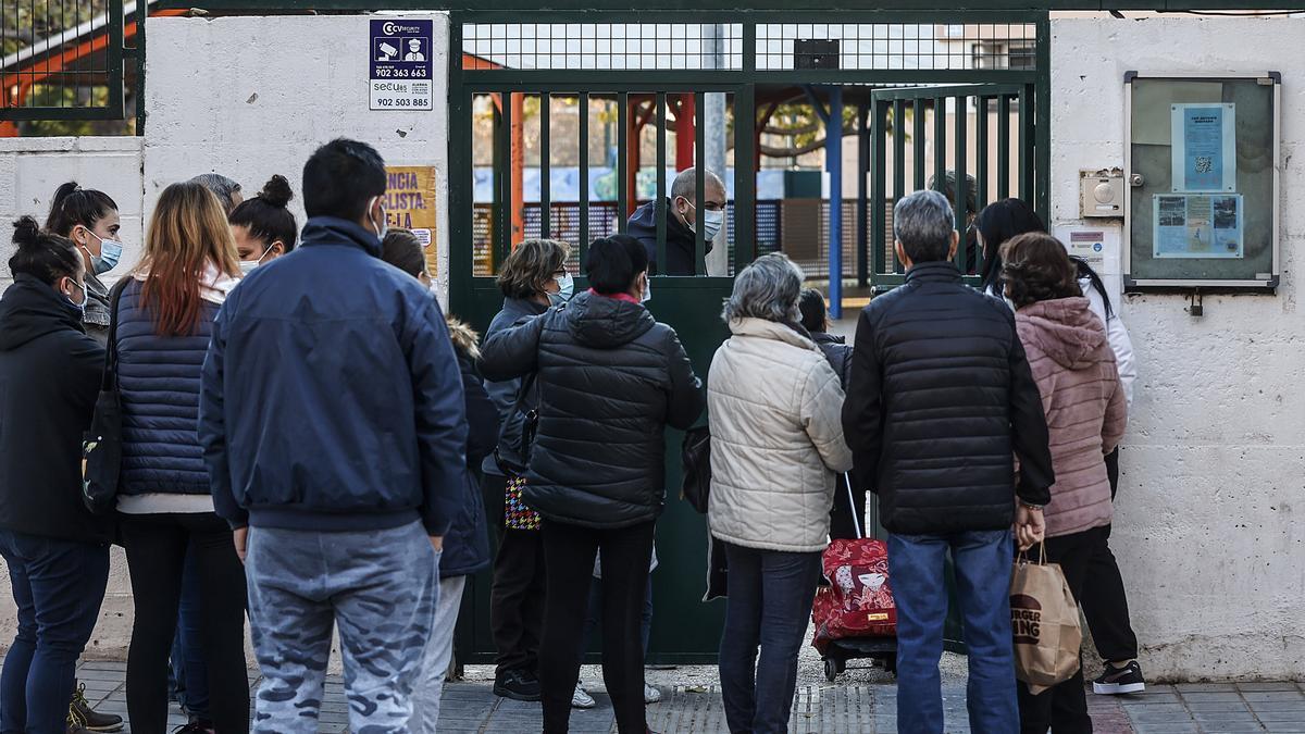 Varios acompañantes de niños y niñas, en la entrada del colegio público CEIP Antonio Machado, a 15 de diciembre de 2021, en Valencia