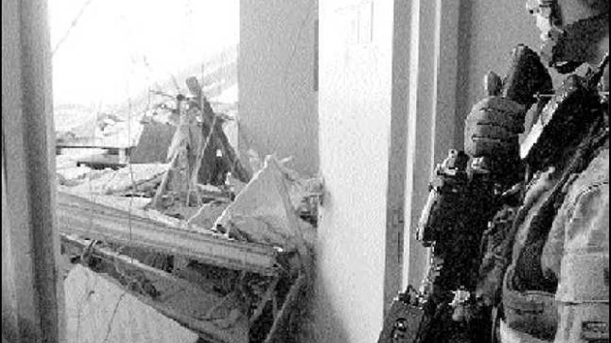 Un soldado norteamericano inspecciona una habitación del hotel Palestina dañada por el impacto del misil.
