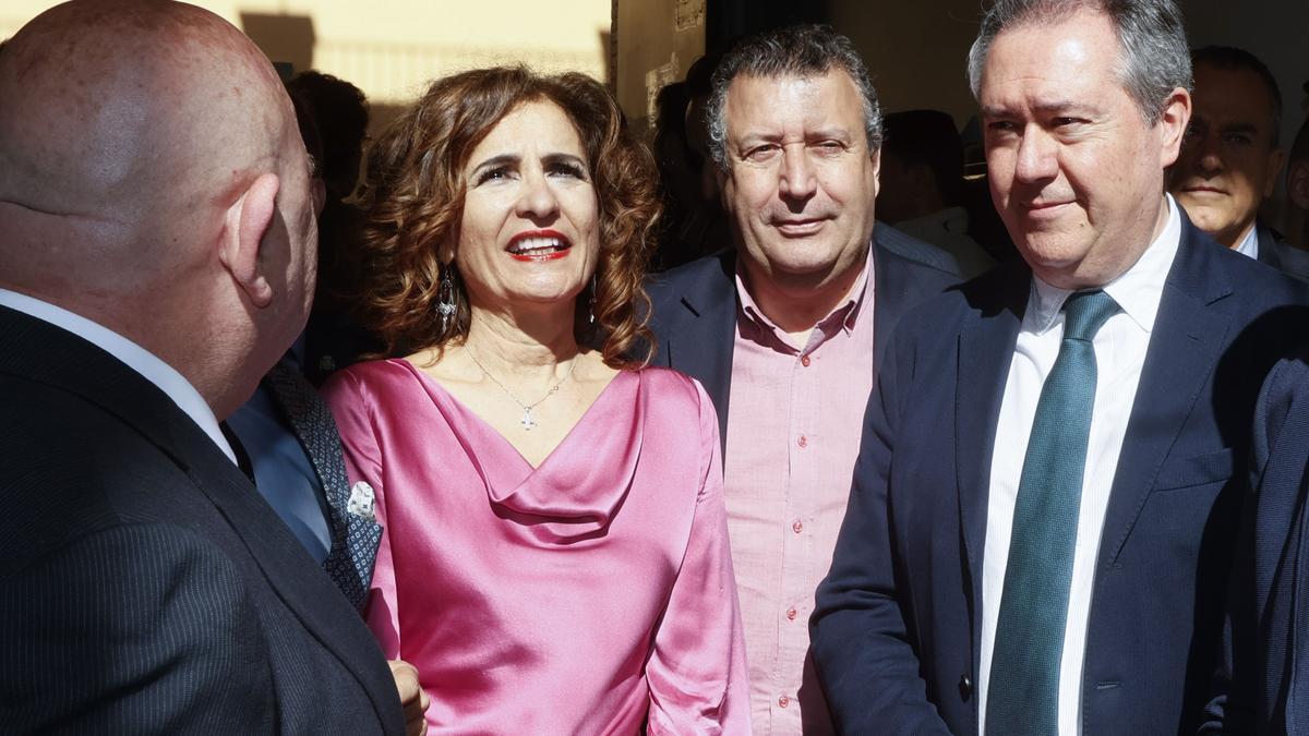 La vicepresidenta primera del Gobierno y ministra de Hacienda, María Jesús Montero, durante su visita este viernes a uno de los talleres de la Asociación Gremial Sevillana de Arte Sacro Corrala de talleres de artesanía, Junto a ella, entre otros, el secretario general del PSOE-A, Juan Espadas (d).