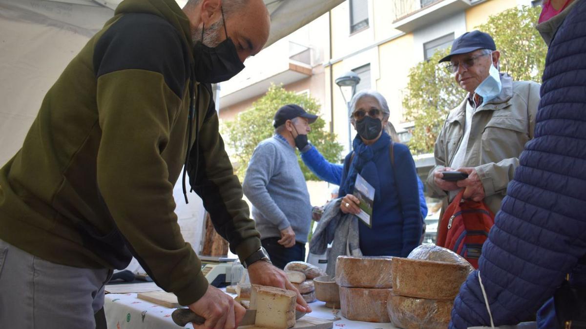 Josep Venturós, de Formatges Cuirols, atén alguns dels assistents al mercat | ARNAU VALVERDE