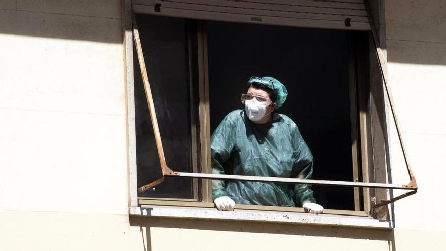 Una enfermera se asoma a la ventana de una clínica en Roma.