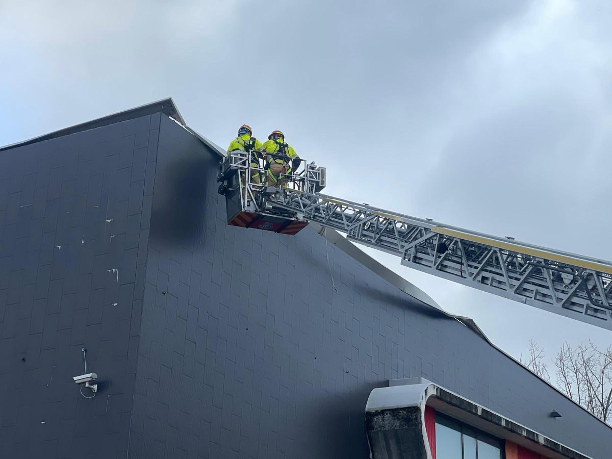 Bomberos del servicio de Emerxencias del Concello de Oleiros retiran material de una cornisa