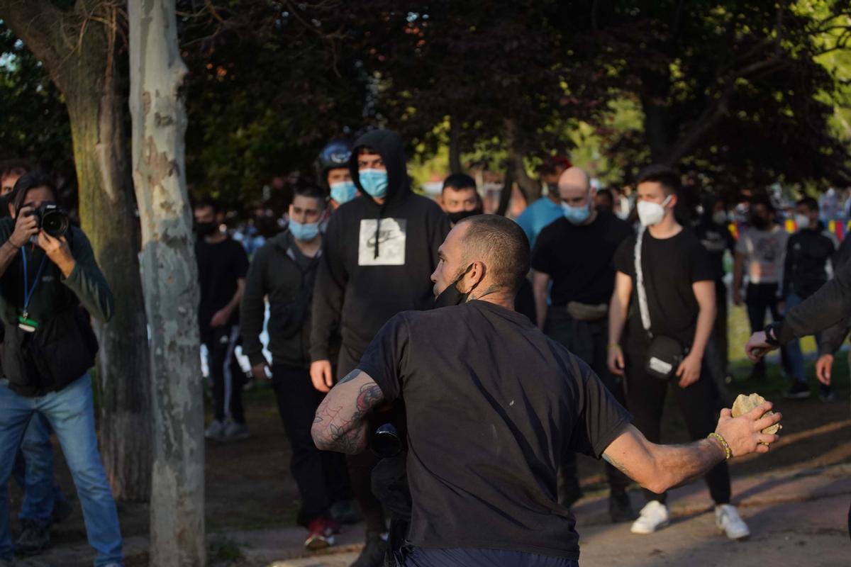 Un manifestante lanzando una piedra en el acto de Vox en Vallecas, Madrid