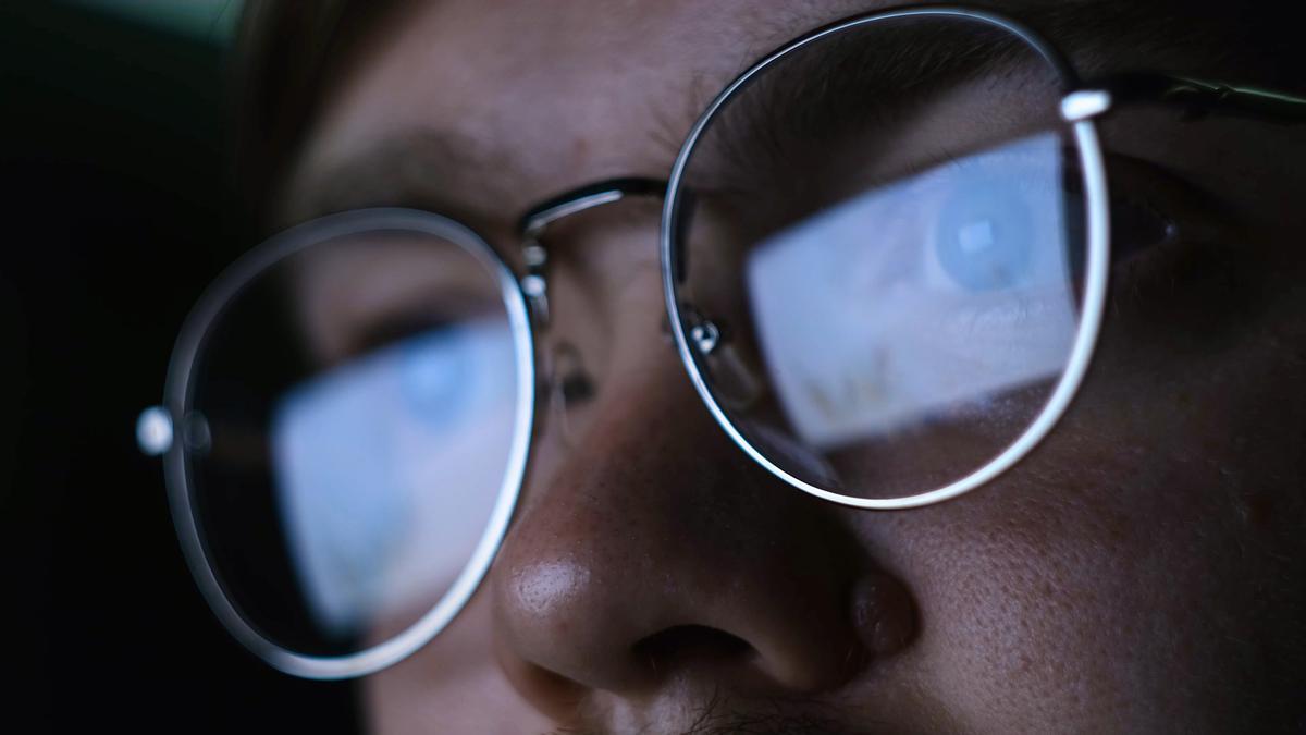 Un hombre con gafas trabaja frente a un ordenador