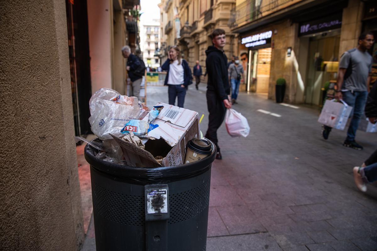 Una papelera llena y desgastada en el centro de Barcelona