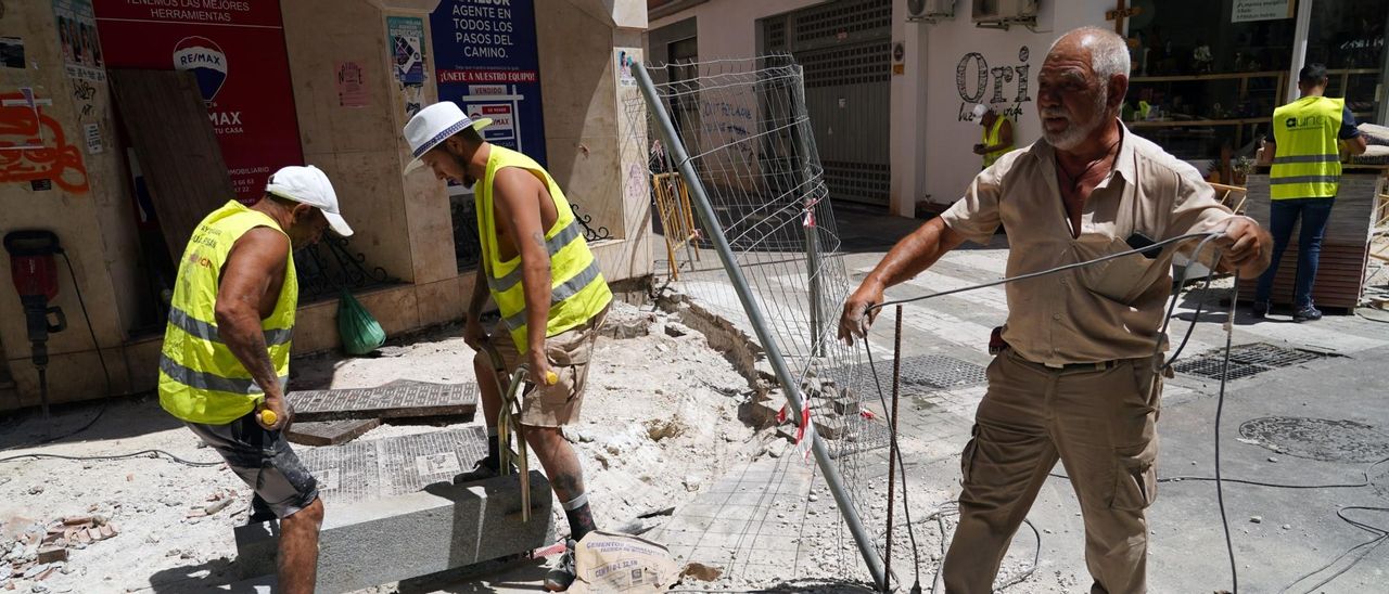 Varios obreros trabajan en la construcción a pleno sol.