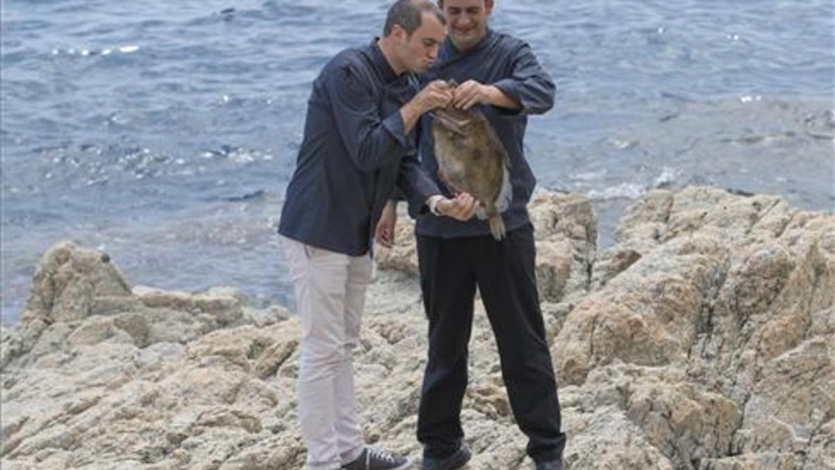 Romain Fornell, que besuquea a un pescado, y José Pulido, en las rocas de S'Agaró. Foto: Glòria Sánchez / Iconna