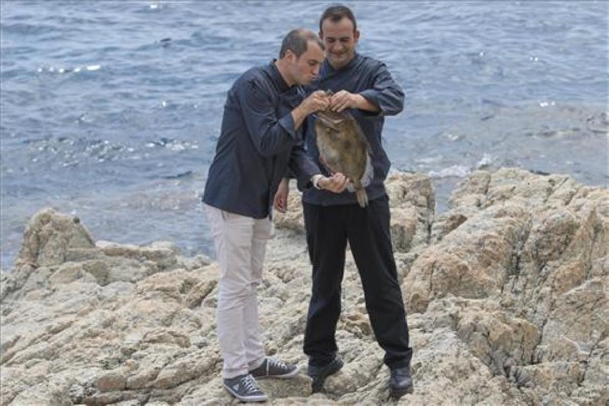 Romain Fornell, que besuquea a un pescado, y José Pulido, en las rocas de S'Agaró. Foto: Glòria Sánchez / Iconna