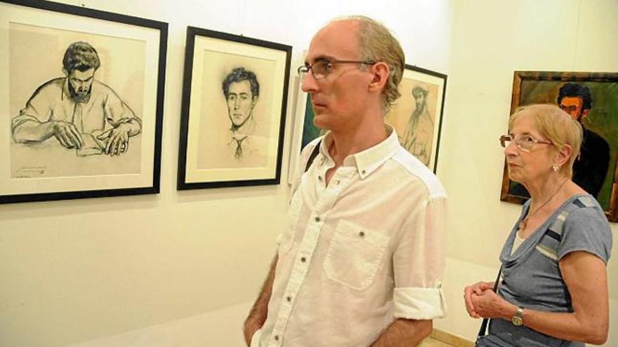 Dos visitants contemplen unes obres exposades al Cercle Artístic