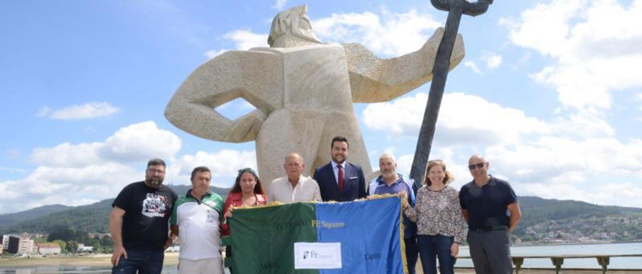 Responsables del Concello, de los dos clubes de remo y de FESeguros, ayer, con la bandera que se pondrá en juego. |  GONZALO NÚÑEZ