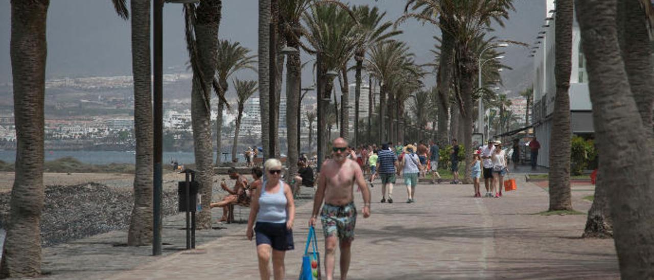 Una pareja de turistas pasea por playa de las Américas, en el municipio tinerfeño de Arona.