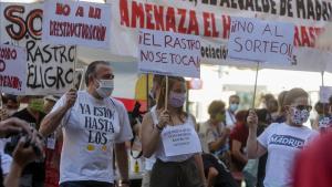 Comerciantes de El Rastro madrileño sostienen pancartas durante la manifestación en la Plaza del Cascorro para exigir sus puestos habituales y recuperar el modelo histórico del mercadillo. 