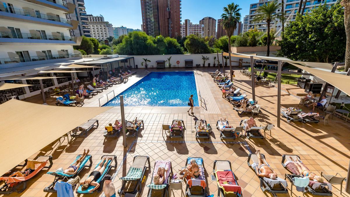 Turistas toman el sol en la piscina de un hotel de Benidorm, este jueves, aprovechando el buen tiempo.