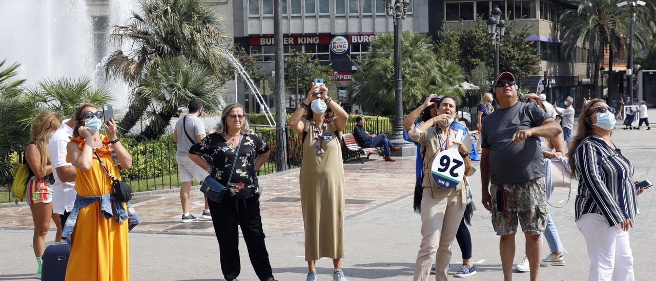 Un grupo de turistas toma fotografías por el centro de València.