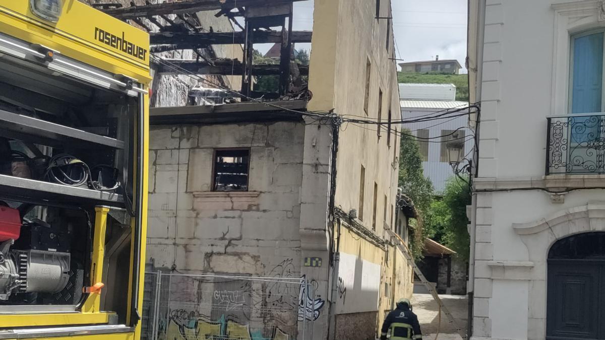 Uno de los bomberos que permanecía esta mañana junto al edificio calcinado