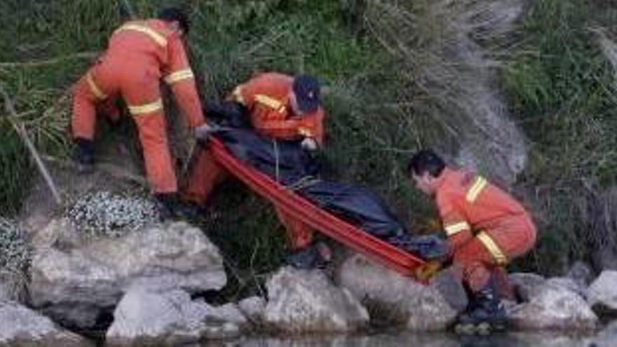 Los bomberos sacan el cuerpo del agua en Riola.