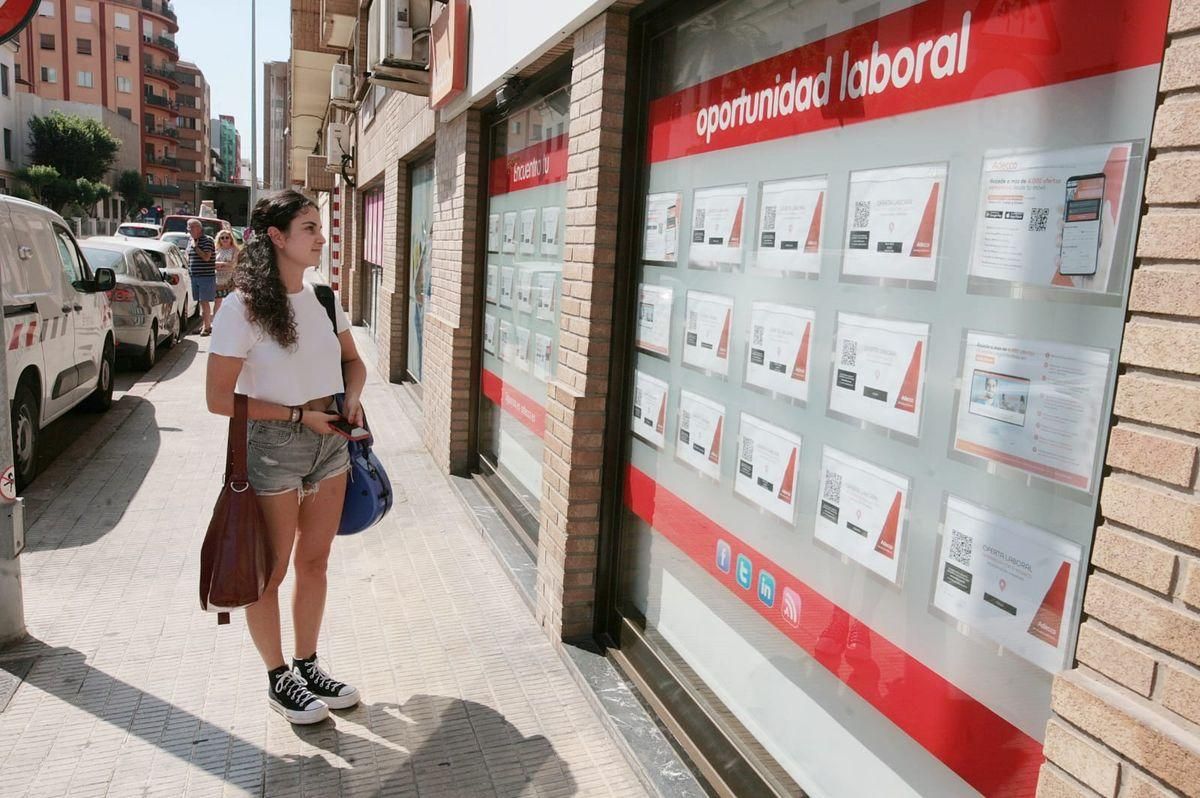 Una joven mira las ofertas de empleo de una ETT en Castellón.