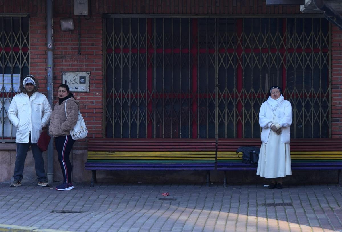 Varias personas esperan desfiando el frío en Cuéllar a que llegue el autobús a Segovia.