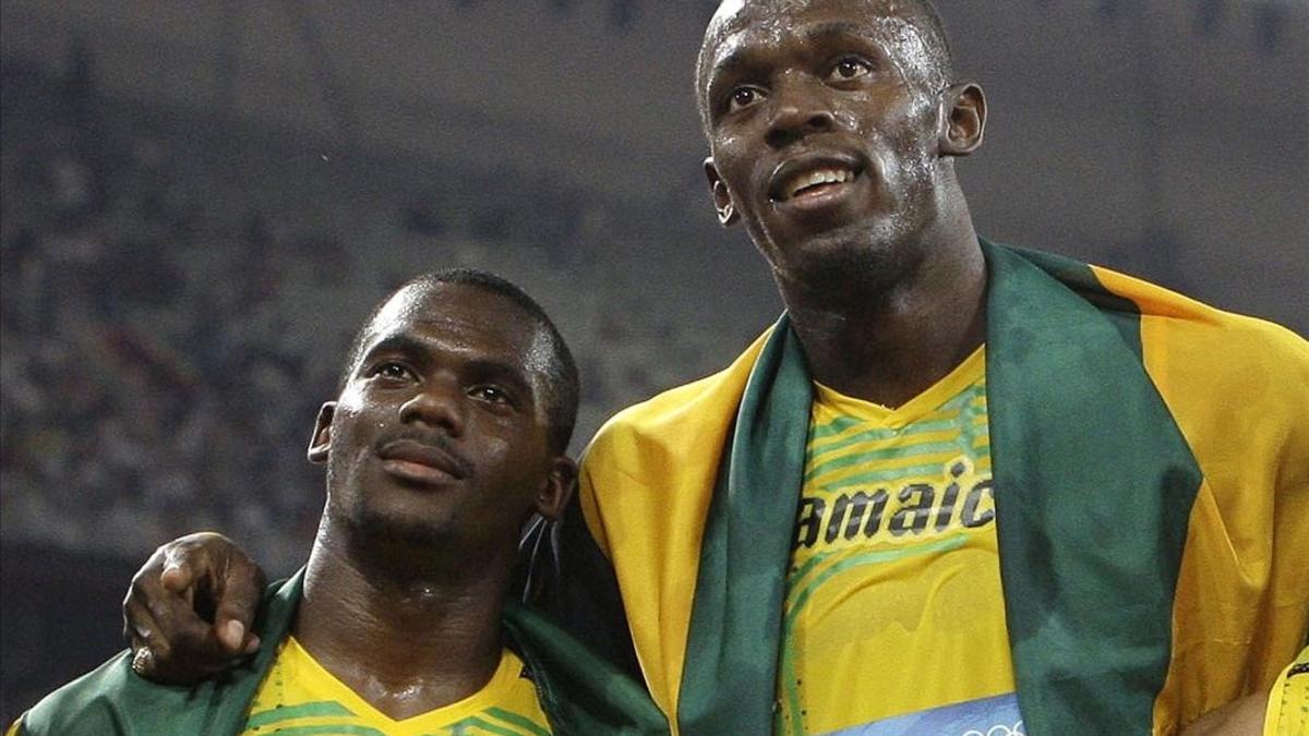 Bolt posa con Carter después de su triunfo en la final del relevo de Pekín