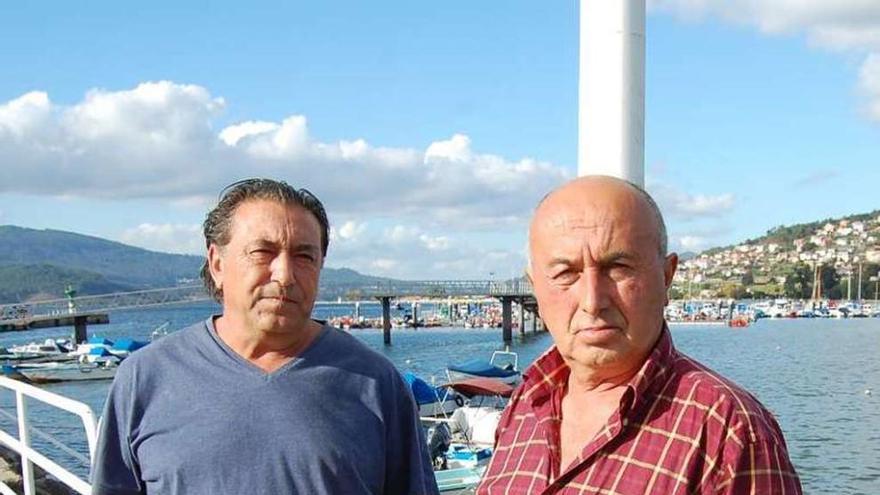 El patrón mayor de Redondela, Clemente Bastos (izq.), con el marinero afectado, Domingo Novelle, ayer en el puerto de Cesantes. // FdV